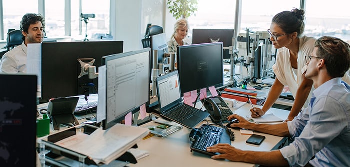 Colleagues collaborating on computers in an office 